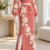 Coral pink crochet skirt set with cream hibiscus flowers and leaf appliqués displayed on a mannequin