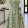 Sage green crochet dress with checker lattice pattern and ivory hem band displayed on white mannequin