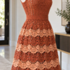 Terracotta and peach crochet dress with fan shell skirt displayed on a white mannequin in a modern room